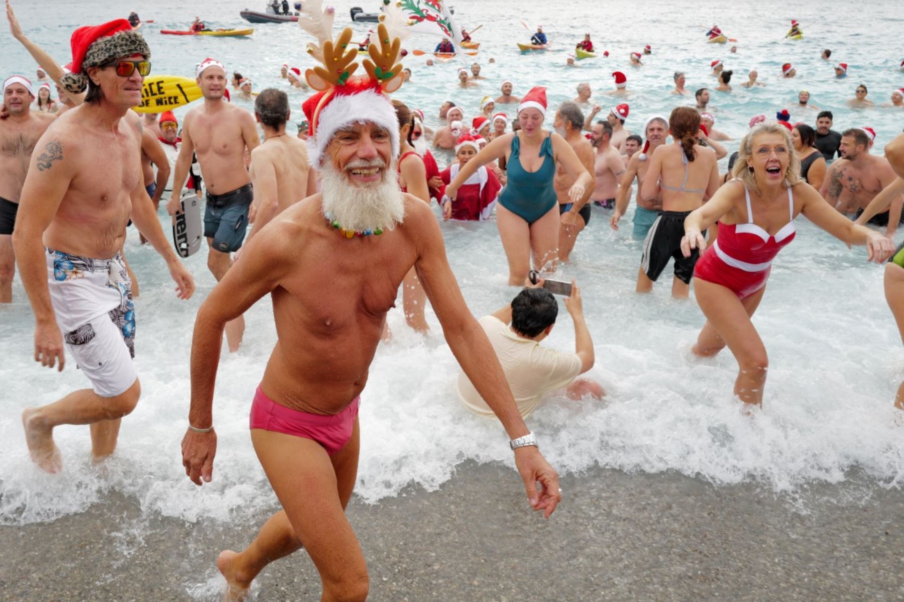 Bañistas vestidos de Papá Noel y otros con gorros navideños participan en el tradicional baño navideño en Niza, en la Riviera Francesa.
Foto: AFP