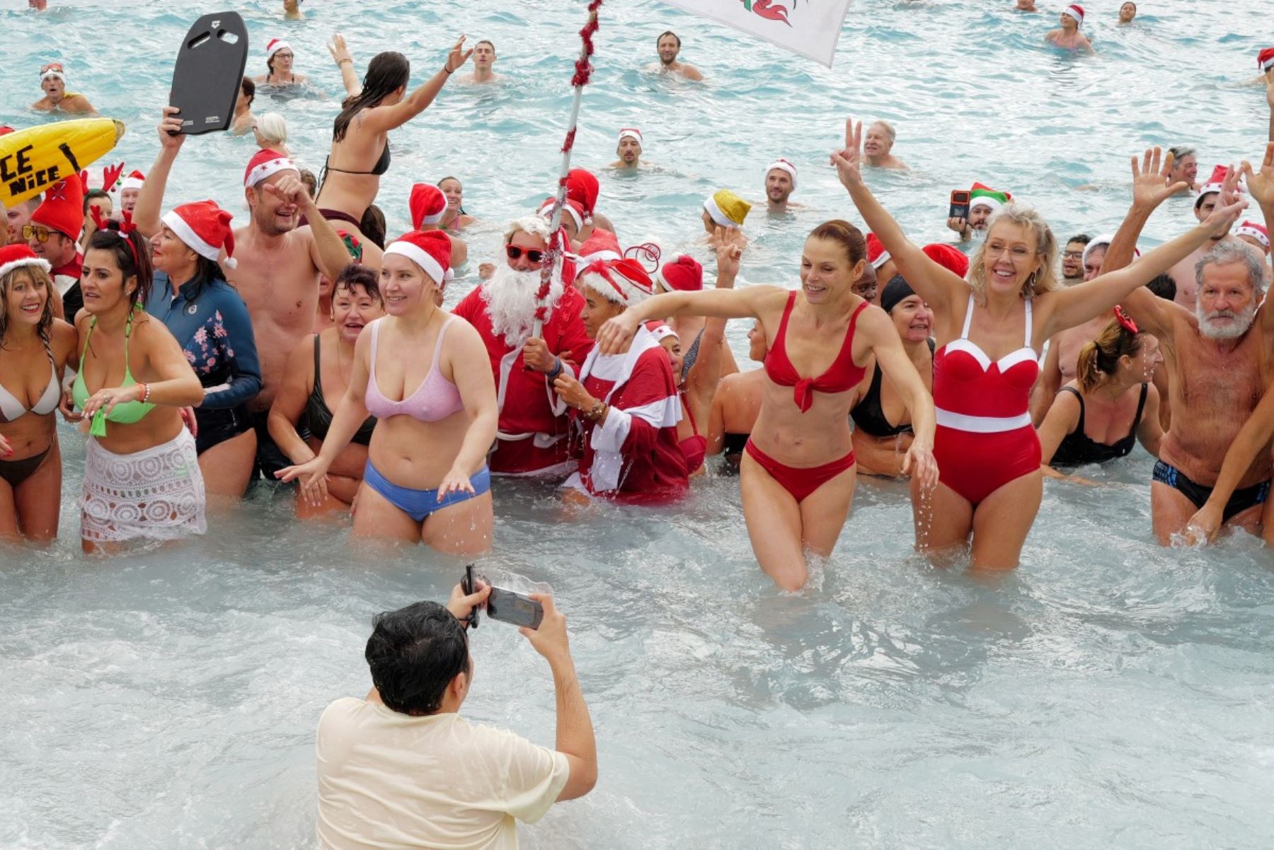 Bañistas vestidos de Papá Noel y otros con gorros navideños participan en el tradicional baño navideño en Niza, en la Riviera Francesa.
Foto: AFP