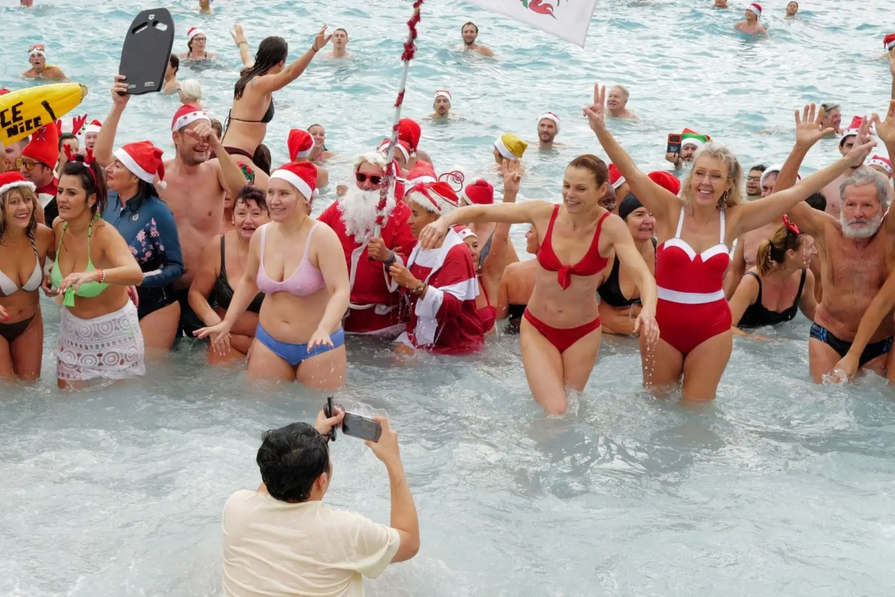 Bañistas vestidos de Papá Noel y otros con gorros navideños participan en el tradicional baño navideño en Niza, en la Riviera Francesa.
Foto: AFP