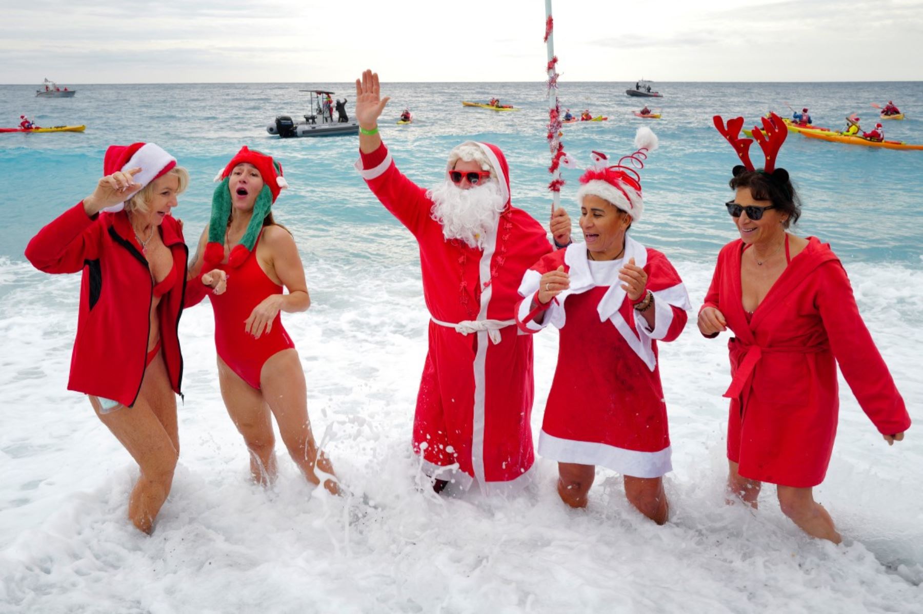 Bañistas vestidos de Papá Noel y otros con gorros navideños participan en el tradicional baño navideño en Niza, en la Riviera Francesa.
Foto: AFP
