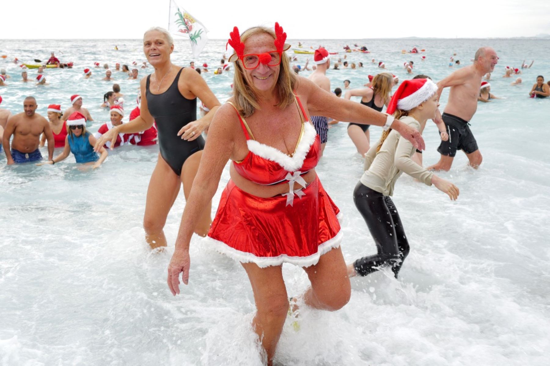 Bañistas vestidos de Papá Noel y otros con gorros navideños participan en el tradicional baño navideño en Niza, en la Riviera Francesa.
Foto: AFP