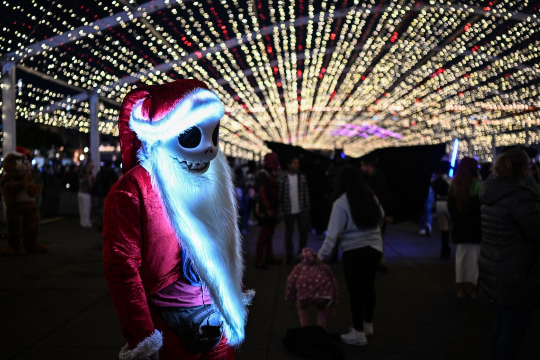 Una persona disfrazada de un personaje de la película "El extraño mundo de Jack" en versión navideña posa para las cámaras durante un festival de luces de Navidad en la plaza del Zócalo de la Ciudad de México el 22 de diciembre de 2025. Foto: AFP