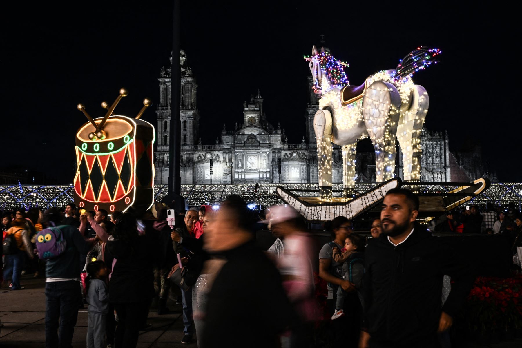 Decenas de mexicanos asisten a un festival de luces de Navidad en la plaza Zócalo de la Ciudad de México el 22 de diciembre de 2025. Foto: AFP