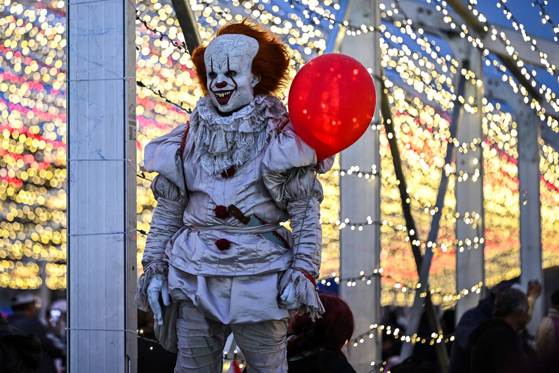Una persona disfrazada de Pennywise, personaje de terror de la película "It", posa para las cámaras durante un festival de luces de Navidad en la plaza del Zócalo de la Ciudad de México el 22 de diciembre de 2025. Foto: AFP
