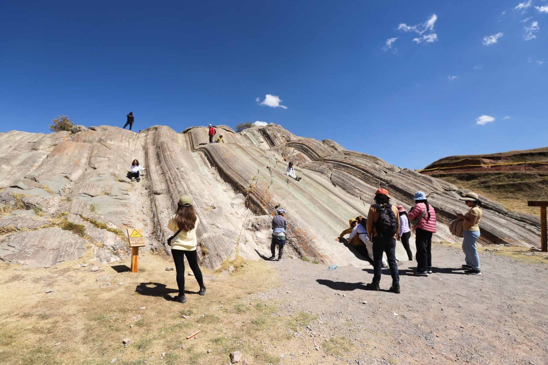 La "resbaladera" en Sacsayhuamán es una formación rocosa natural de diorita pulida, parte del complejo arqueológico, donde los visitantes, especialmente niños y adultos, disfrutan deslizándose, siendo un lugar icónico para la diversión y perder el miedo en este gran sitio inca, además de admirar la ingeniería y las enormes piedras.  Foto: ANDINA/Difusión