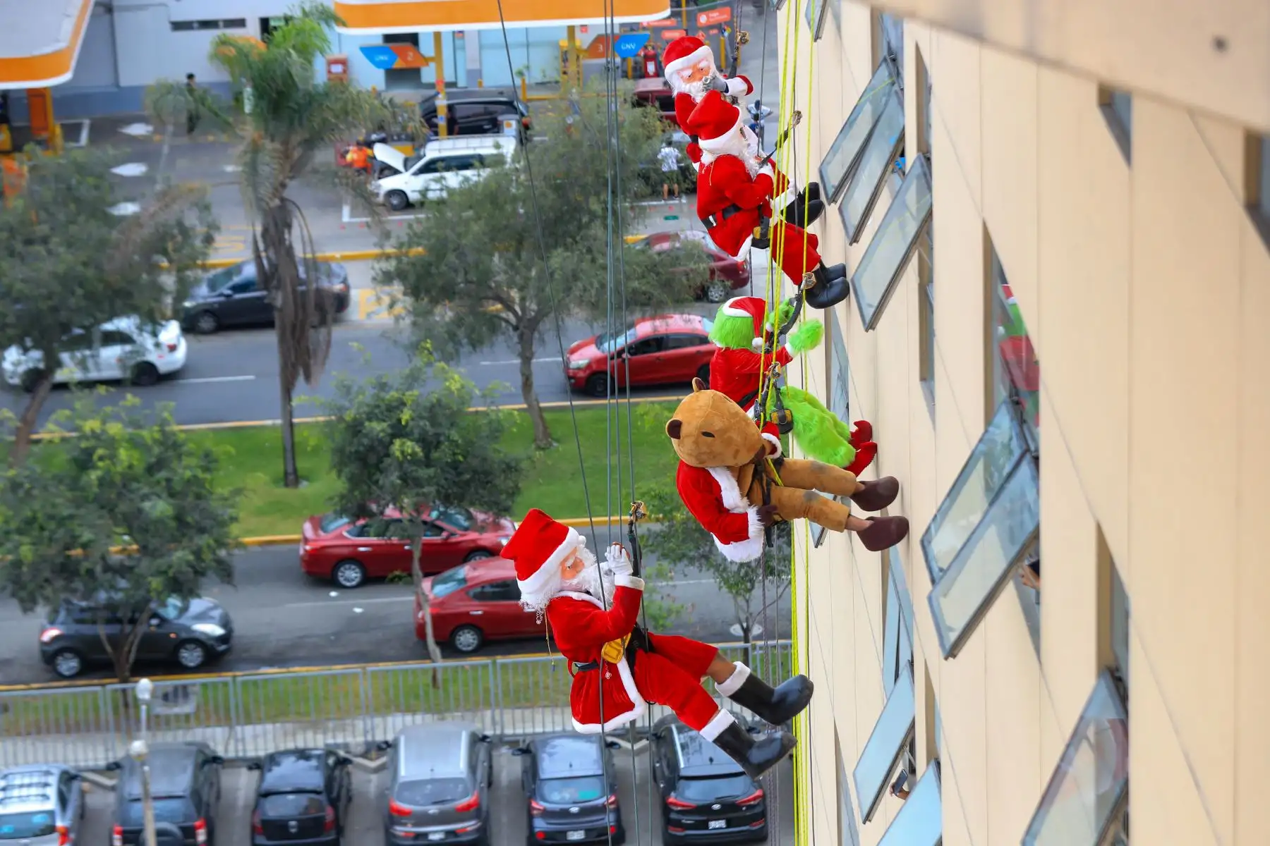 Tres papanoeles acompañados de el grinch y un simpático capibara navideño, bajaron mediante cuerdas especiales hacia distintas áreas del INSN para repartir juguetes y alegría a los pequeños pacientes del INSN San Borja. Foto: ANDINA/Ricardo Cuba