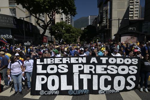 Manifestantes sostienen una pancarta exigiendo la liberación de todos los presos políticos en Venezuela (imagen de enero de 2025). Foto: AFP