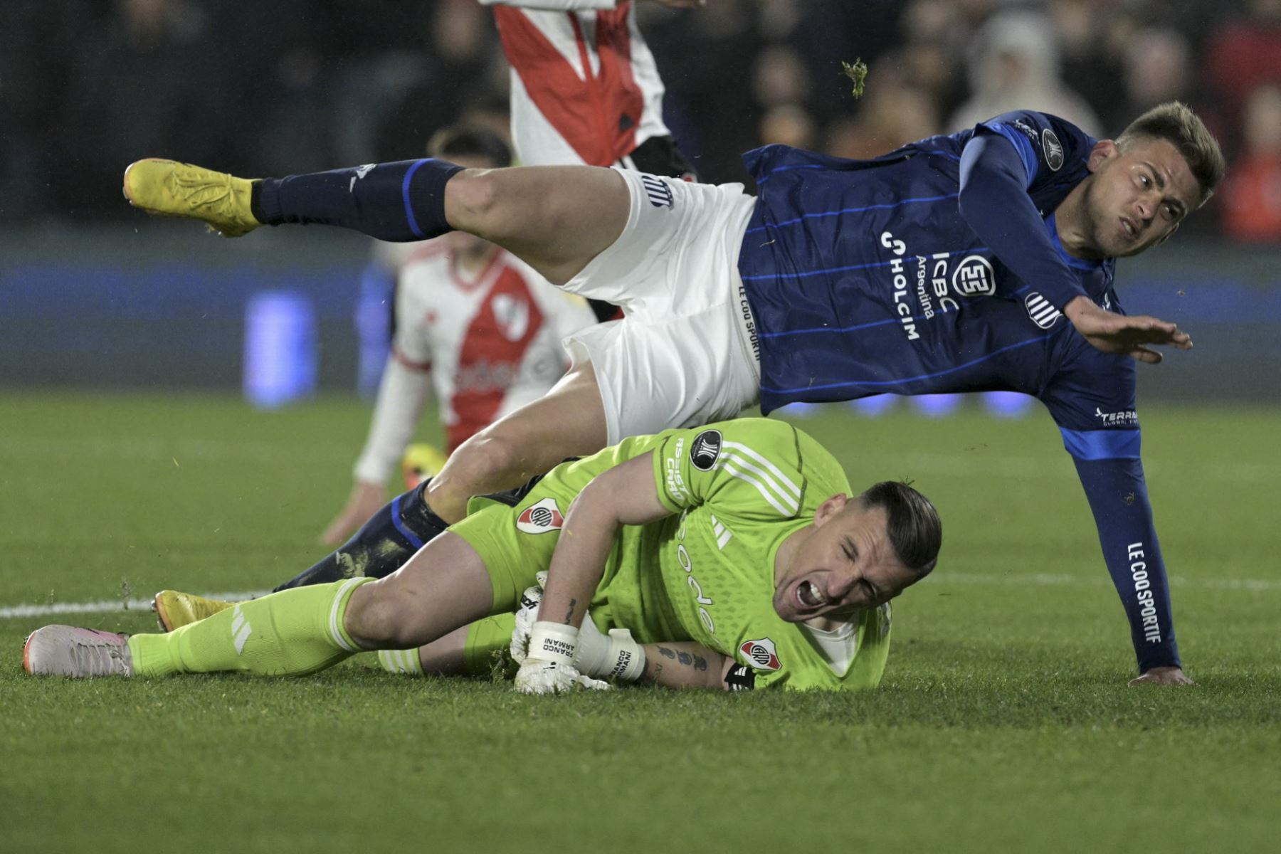 El delantero de Talleres, Federico Girotti (arriba), cae sobre el portero de River Plate, Franco Armani, después de anotar el balón durante el partido de vuelta de vuelta de la Copa Libertadores entre River Plate y Talleres de Córdoba en el estadio Mas Monumental de Buenos Aires el 21 de agosto de 2024. (Foto de JUAN MABROMATA / AFP)