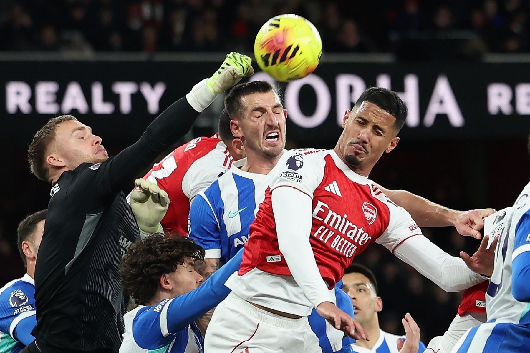 El portero del Brighton, Bart Verbruggen, salva un balón frente a William Saliba, del Arsenal, durante el partido de la Premier League inglesa entre el Arsenal FC y el Brighton. Foto: ANDINA/EFE