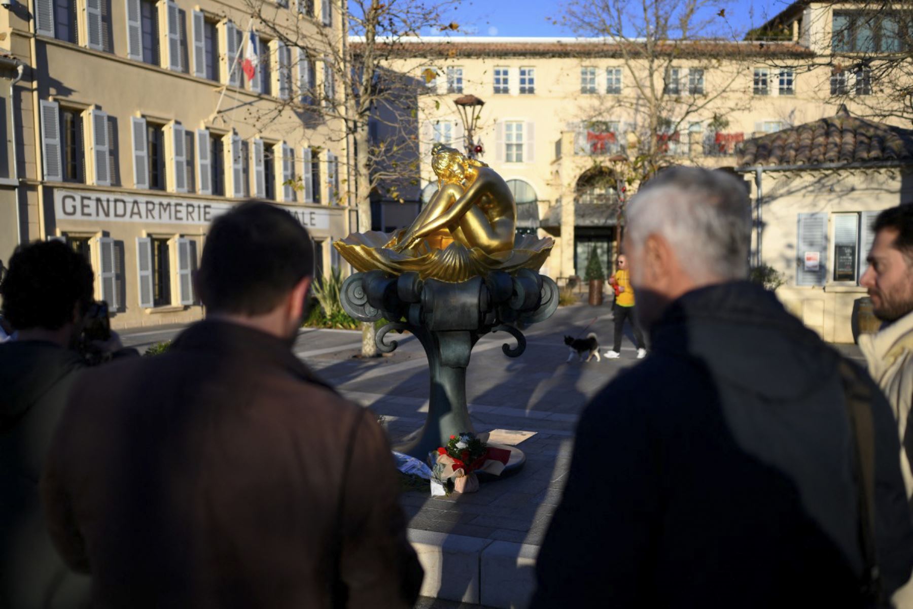 Los dolientes se paran alrededor de la estatua de la difunta actriz francesa y activista por los derechos de los animales Brigitte Bardot, creada a partir de una obra de arte del autor de cómics italiano Milo Manara, en la Plaza Blanqui en Saint-Tropez, al sureste de Francia, el 28 de diciembre de 2025. La leyenda del cine francés Brigitte Bardot murió a los 91 años. AFP se enteró de la Fundación Brigitte Bardot el 28 de diciembre de 2025. (Foto de FREDERIC DIDES / AFP)