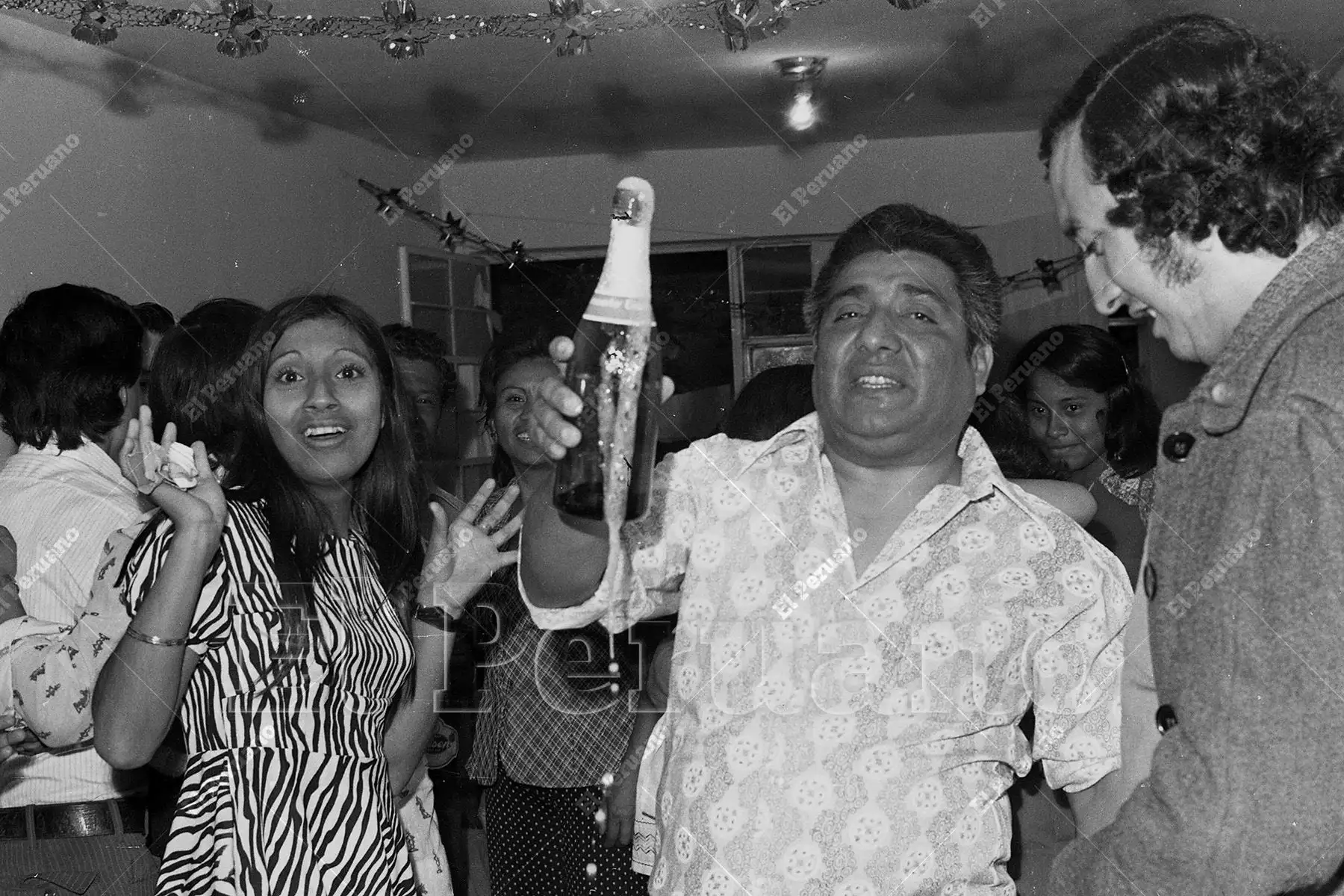Lima – 1 enero  1975 / Alegría desbordante en una celebración familiar de Año Nuevo en San Juan de Miraflores, donde el descorche del champán marca el inicio festivo de un nuevo año entre risas y baile. Foto: Archivo Histórico de El Peruano / Braulio Cabrera