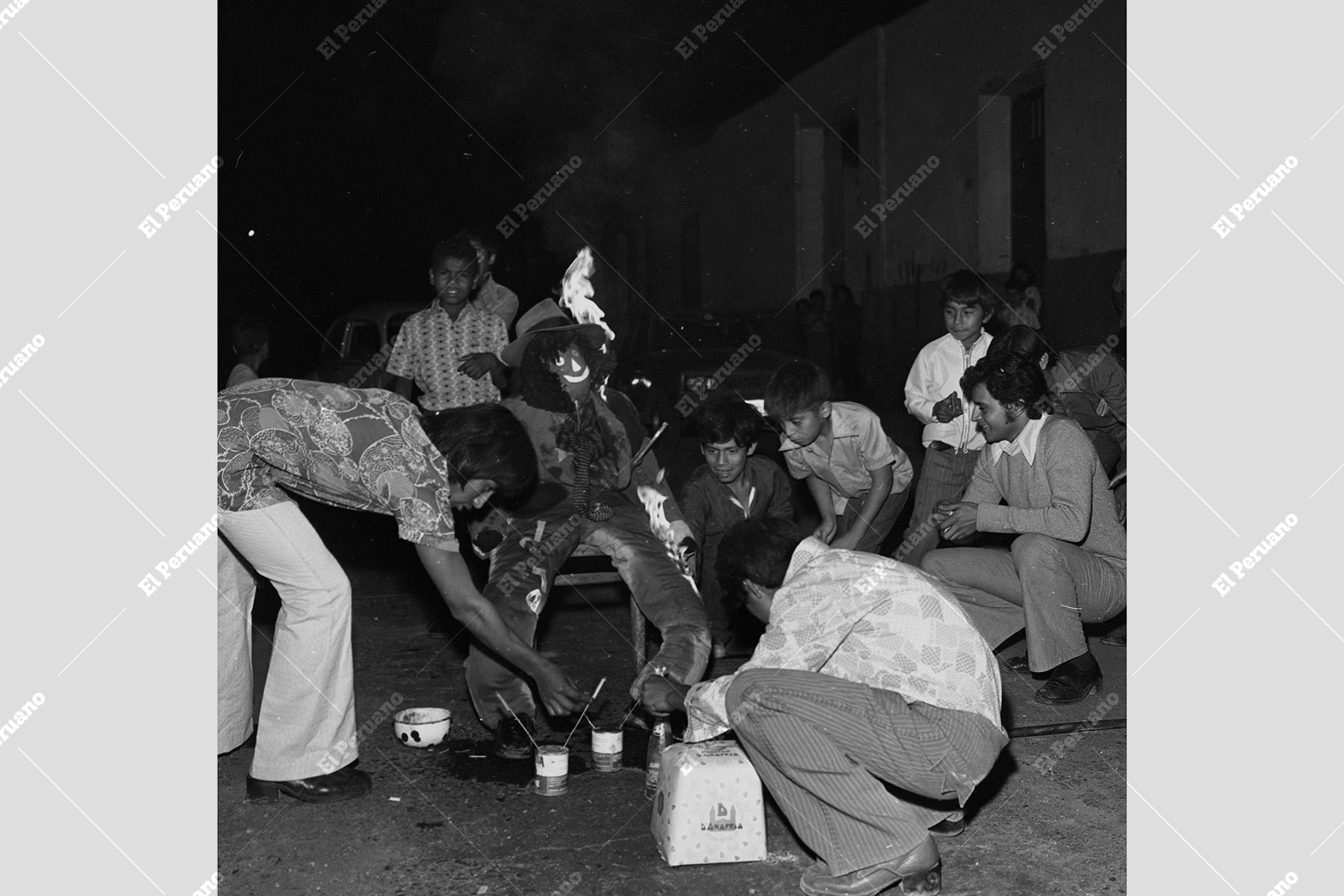 Lima - 1 enero 1975 / Preciso instante en el que dos jóvenes encienden el tradicional muñeco ante la entusiasta mirada de un grupo de niños  para celebrar así el fin del año 1974 y el comienzo del Año Nuevo 1975. Foto: Archivo Histórico de El Peruano / Raúl Sagástegui