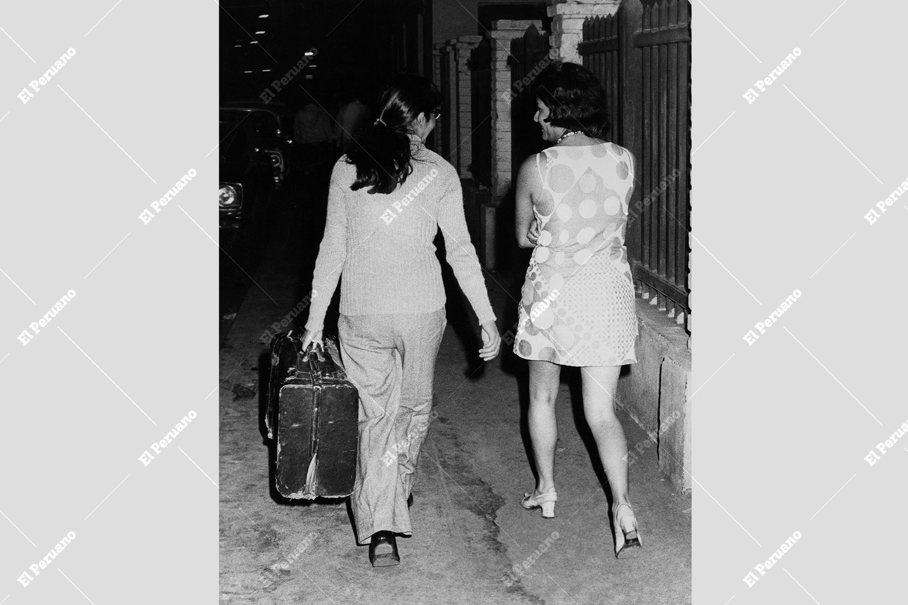 Lima – diciembre 1976 / Dos vecinas recorren la manzana con una maleta en mano, siguiendo la tradicional creencia de Año Nuevo que augura viajes y nuevas experiencias en el año por venir. Foto: Archivo Histórico de El Peruano