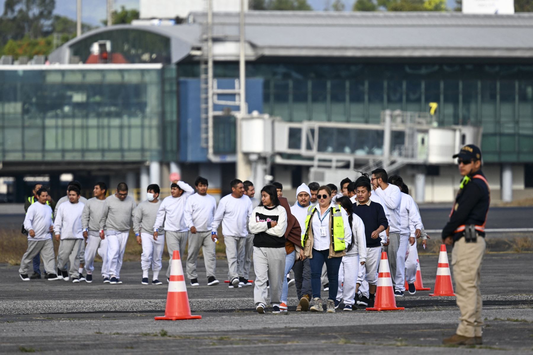 Migrantes guatemaltecos deportados de Estados Unidos caminan por una pista de aterrizaje después de llegar a la Base de la Fuerza Aérea Guatemalteca en la Ciudad de Guatemala el 30 de diciembre de 2025, durante el último vuelo de deportados del año. Foto: AFP