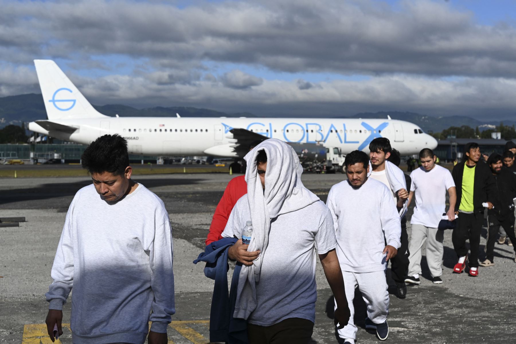 Migrantes guatemaltecos deportados de Estados Unidos caminan por una pista de aterrizaje después de llegar a la Base de la Fuerza Aérea Guatemalteca en la Ciudad de Guatemala el 30 de diciembre de 2025, durante el último vuelo de deportados del año. Foto: AFP