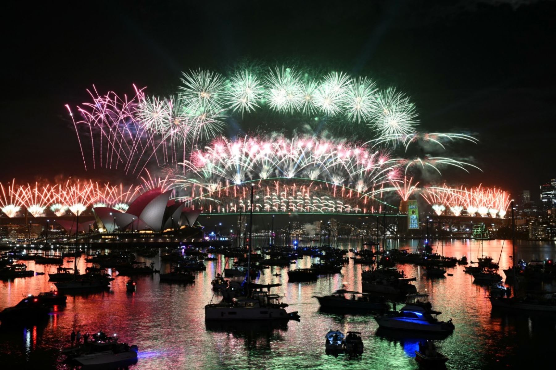 Los fuegos artificiales iluminan el cielo de medianoche sobre el Puente del Puerto de Sídney y la Ópera de Sídney durante las celebraciones del Día de Año Nuevo en Sídney. AFP