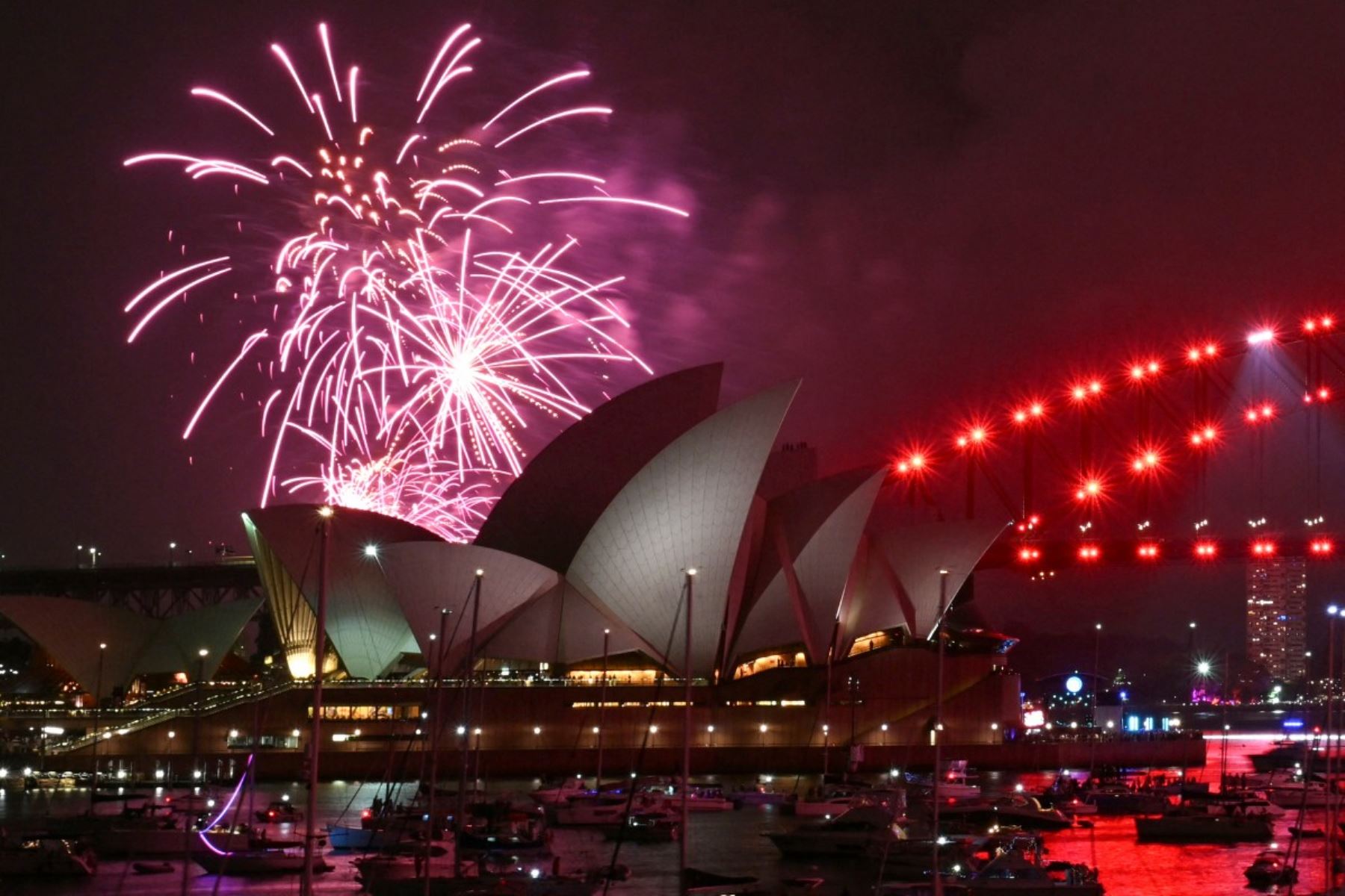 Los fuegos artificiales iluminan el cielo de medianoche sobre el Puente del Puerto de Sídney y la Ópera de Sídney durante las celebraciones del Día de Año Nuevo en Sídney. AFP