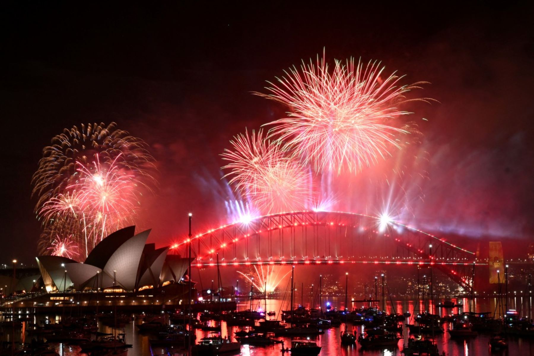 Los fuegos artificiales iluminan el cielo de medianoche sobre el Puente del Puerto de Sídney y la Ópera de Sídney durante las celebraciones del Día de Año Nuevo en Sídney. AFP