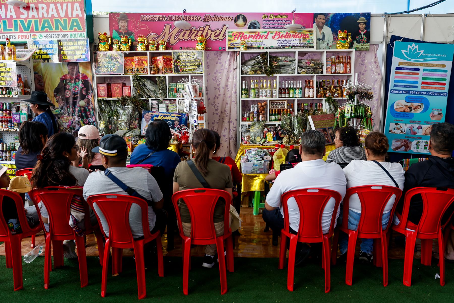 Personas aguardan sentadas su turno para acceder a lecturas y rituales ofrecidos por curanderas durante la feria. La espera forma parte del recorrido de fe y expectativa, en el que los asistentes confían en recibir orientación espiritual para encaminar decisiones y deseos relacionados con el trabajo, la salud y la prosperidad. Foto: ANDINA/Luis Iparraguirre