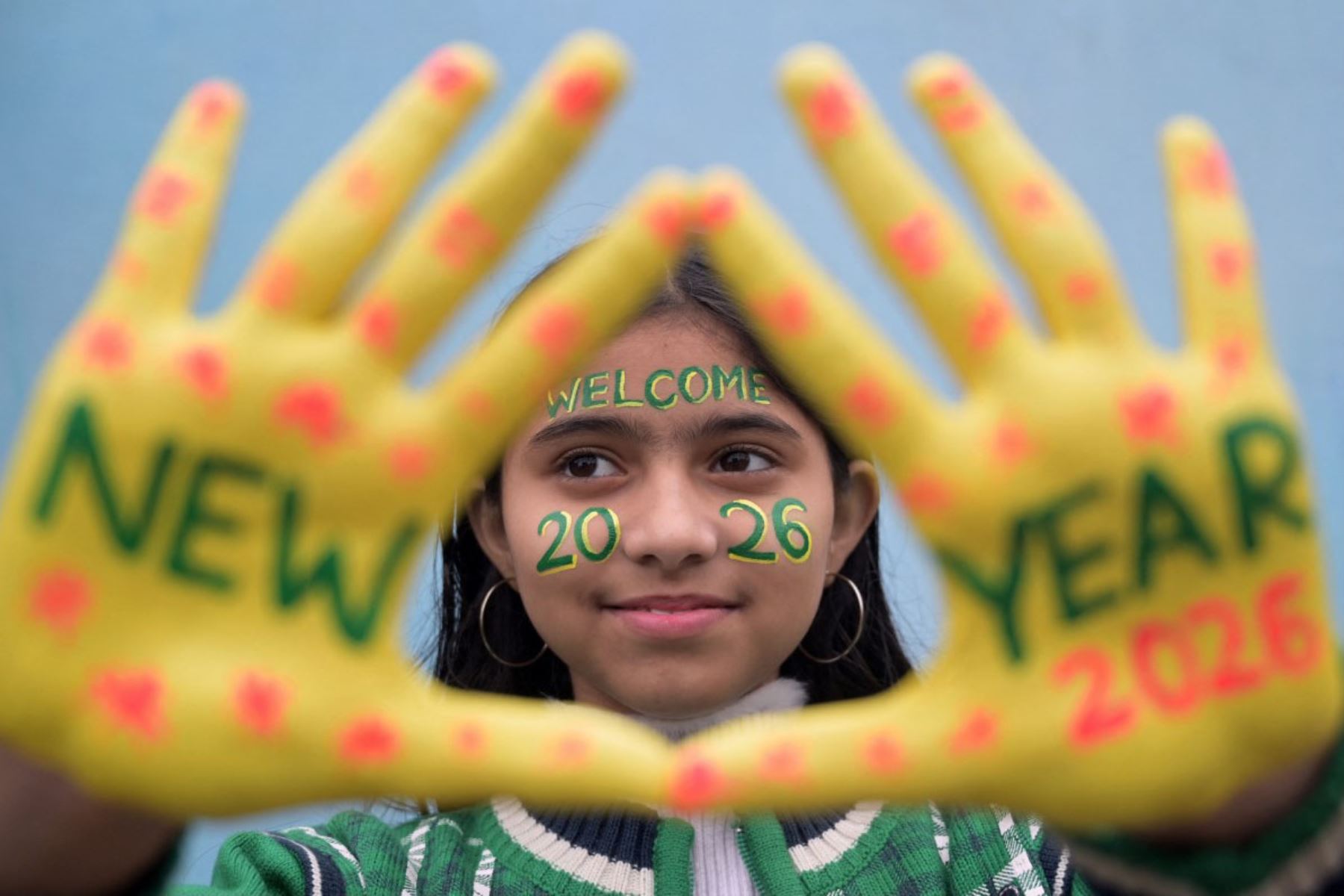 Una niña posa con la cara y las manos pintadas durante las celebraciones de Nochevieja en Amritsar el 31 de diciembre de 2025. 
Foto: AFP