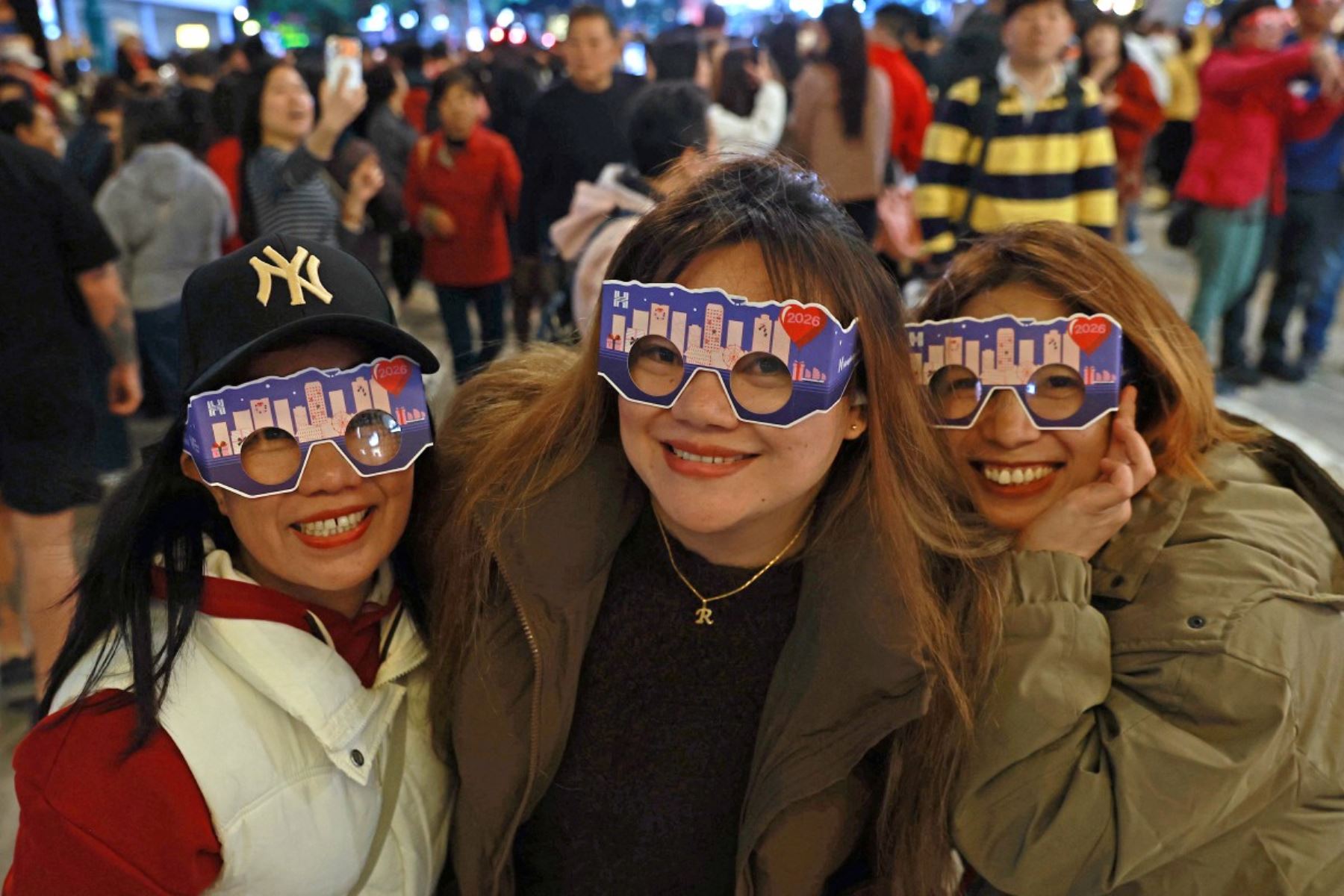 Los asistentes posan para fotos mientras esperan la cuenta regresiva de medianoche durante las celebraciones de Año Nuevo en Hong Kong el 31 de diciembre de 2025. 
Foto: AFP