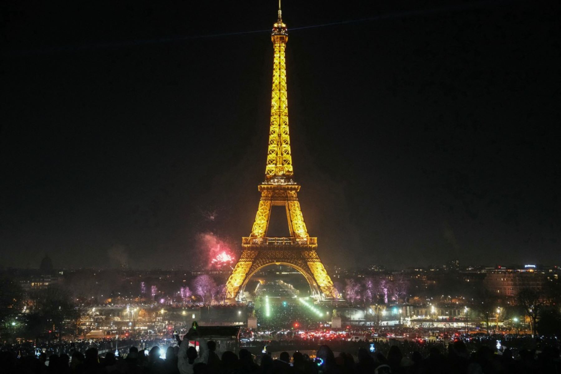 La gente se reúnen en la Torre Eiffel para dar la bienvenida al Año Nuevo, en el centro de París el 31 de diciembre de 2025. (Foto de Dimitar DILKOFF / AFP)