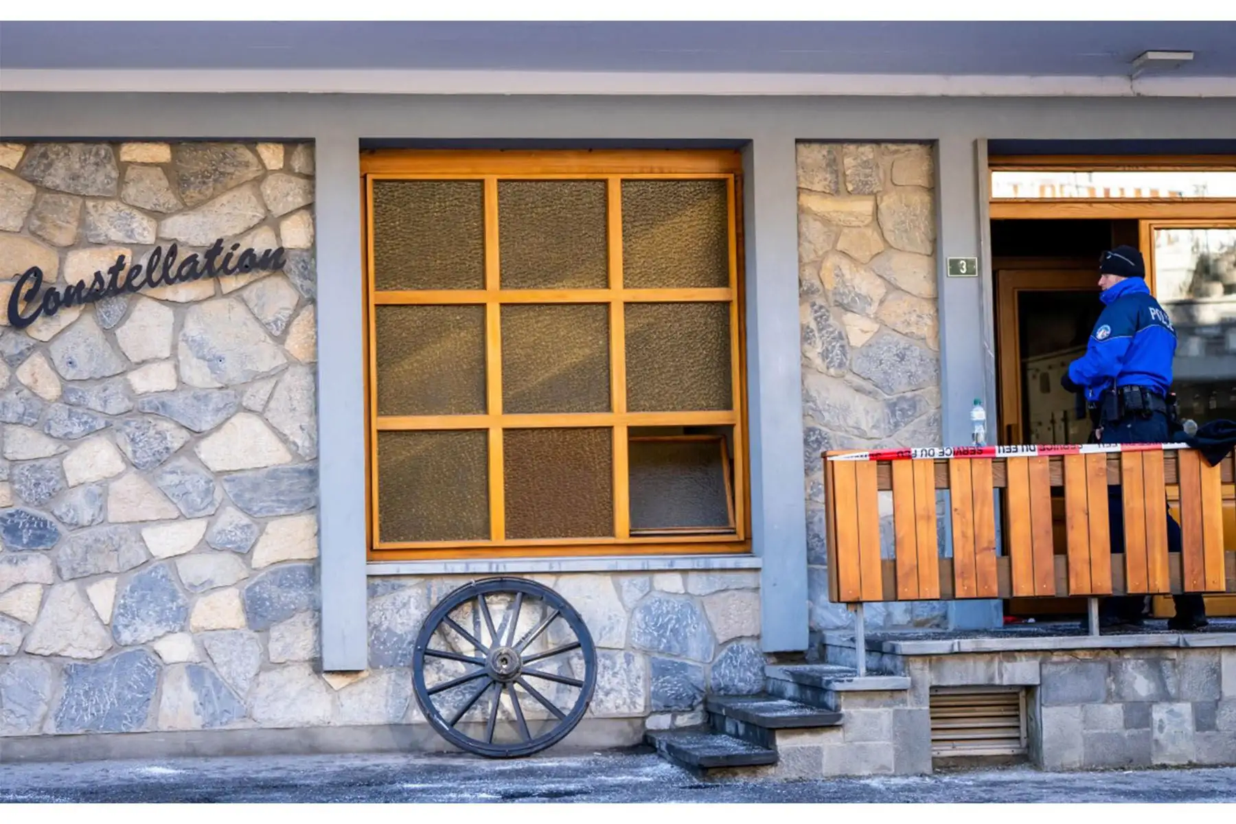 Un agente de policía se encuentra a la entrada del edificio donde se encuentra el bar Le Constellation, tras el incendio que arrasó el local en Crans-Montana, Suiza, el 1 de enero de 2026, durante las celebraciones de Año Nuevo. Foto: AFP