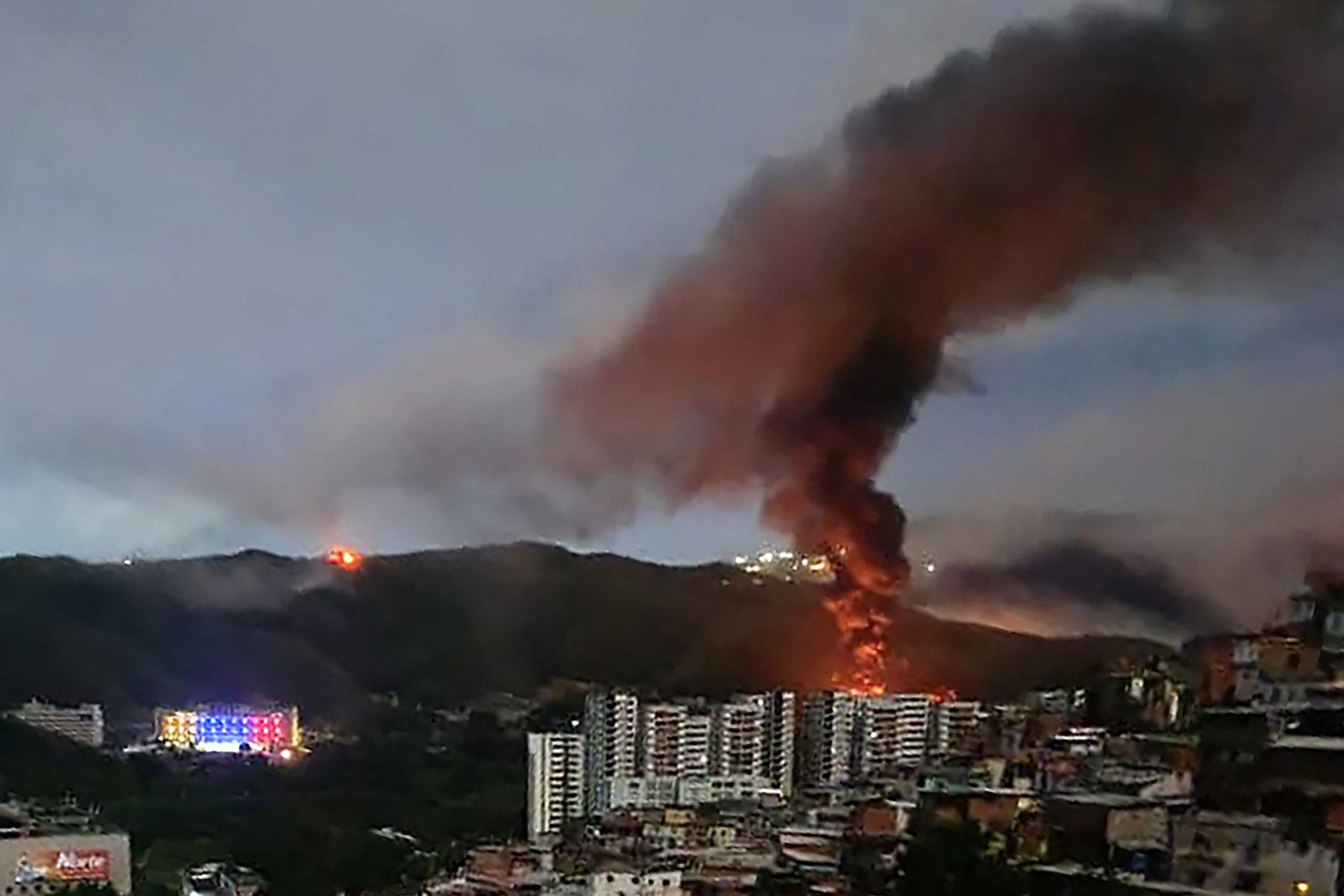 Incendio en Fuerte Tiuna, el mayor complejo militar de Venezuela, visto a distancia tras una serie de explosiones en Caracas el 3 de enero de 2026. El ejército estadounidense estuvo detrás de una serie de ataques contra Caracas, la capital venezolana, el sábado, según informaron medios estadounidenses. Foto: AFP