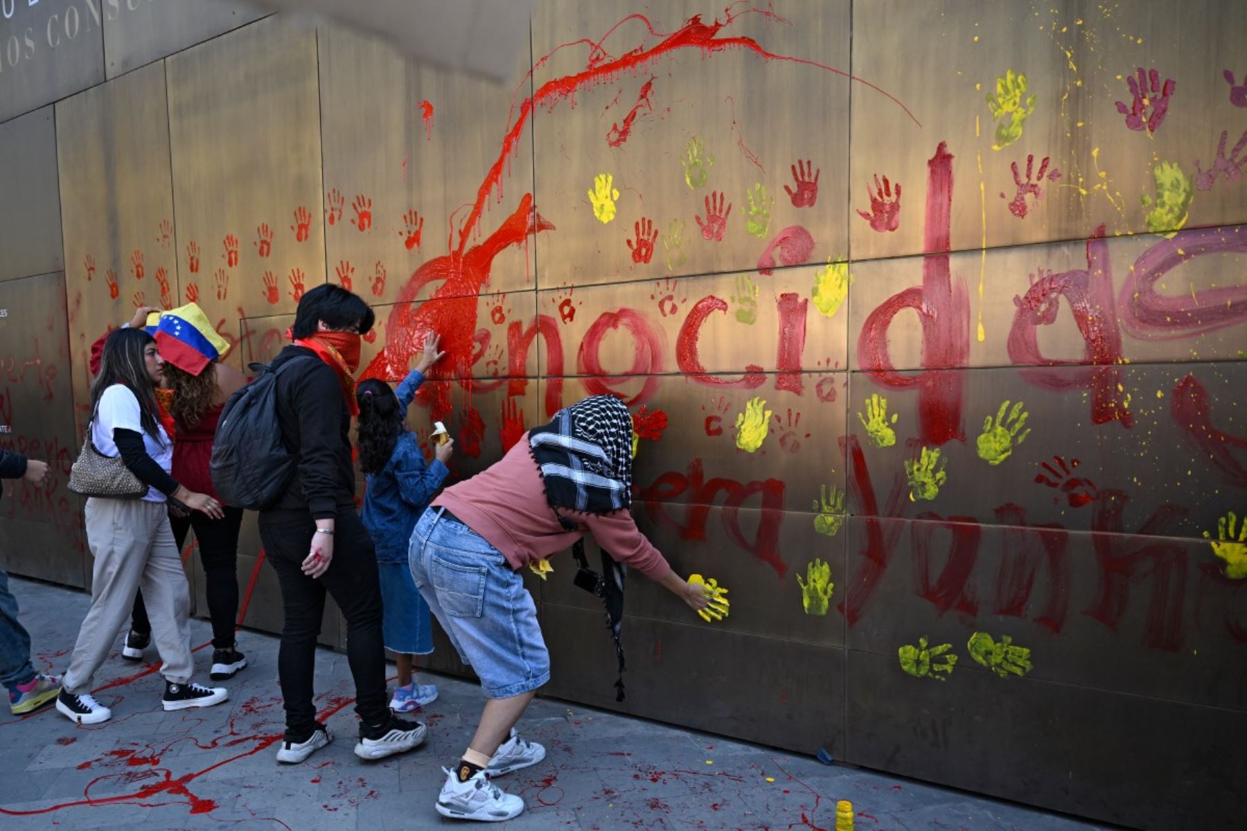 Integrantes de organizaciones sociales realizaron pintas y dejaron huellas de manos con pintura en un muro cercano a la embajada de Estados Unidos en Ciudad de México, en protesta por la operación militar estadounidense en Venezuela y la captura de Nicolás Maduro, a la que calificaron como un acto de intervención. Foto: AFP