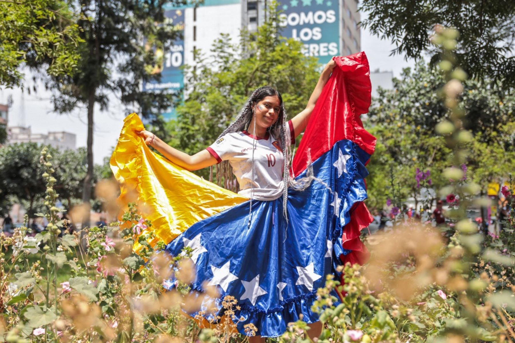 Reymaris, venezolana residente en Perú desde hace cuatro años, posa en el parque Miguel de Cervantes, cerca de la embajada de Venezuela en Lima, envuelta en una falda con los colores de su bandera. La imagen refleja la mezcla de orgullo, alivio y esperanza tras la captura de Nicolás Maduro. Foto: AFP