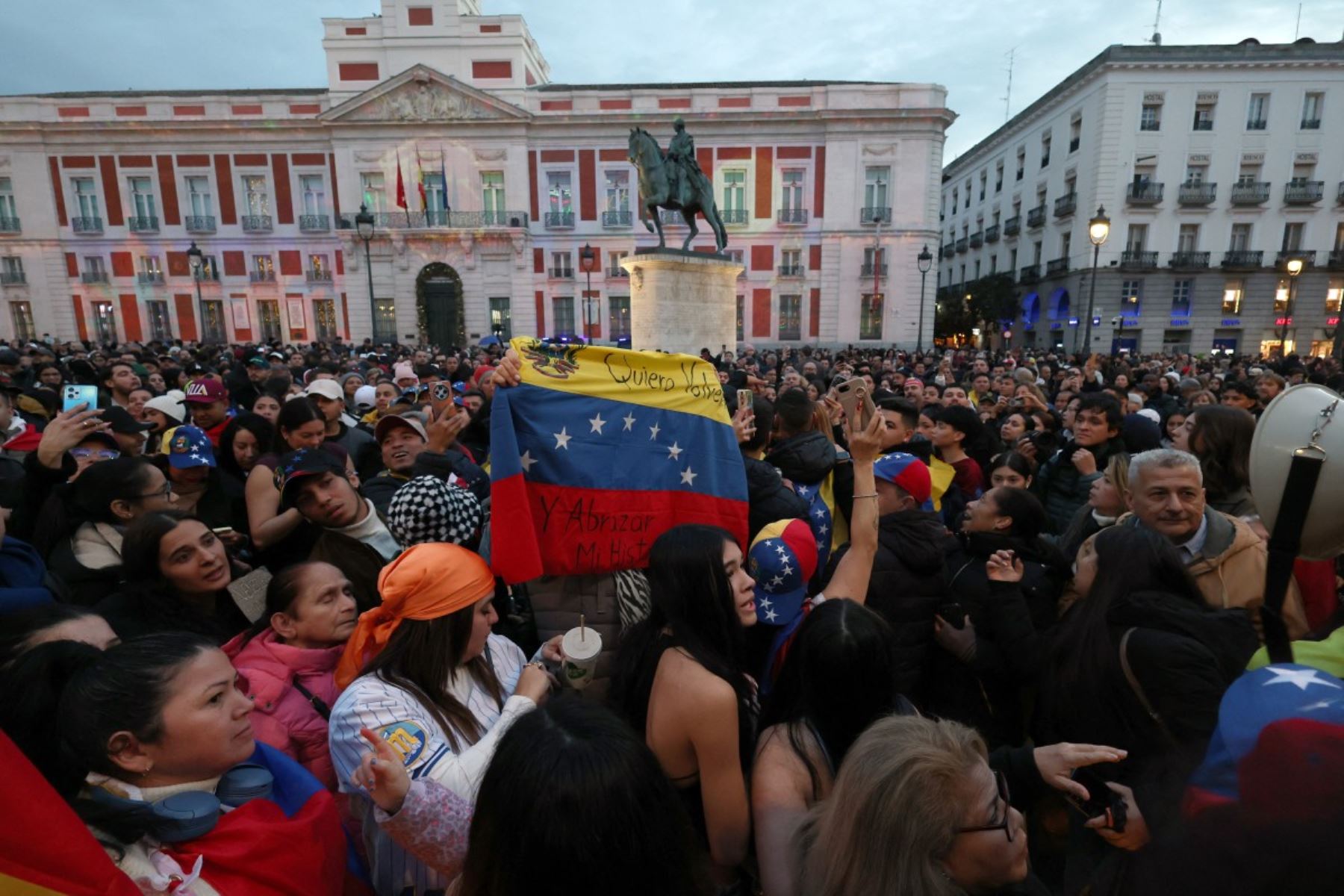 Venezolanos residentes en España se congregan en la Puerta del Sol, en Madrid, tras conocerse la captura de Nicolás Maduro por fuerzas estadounidenses. Entre banderas, teléfonos en alto y mensajes escritos a mano, la multitud expresó alivio, emoción y esperanza ante un eventual cambio político en Venezuela. Foto: AFP