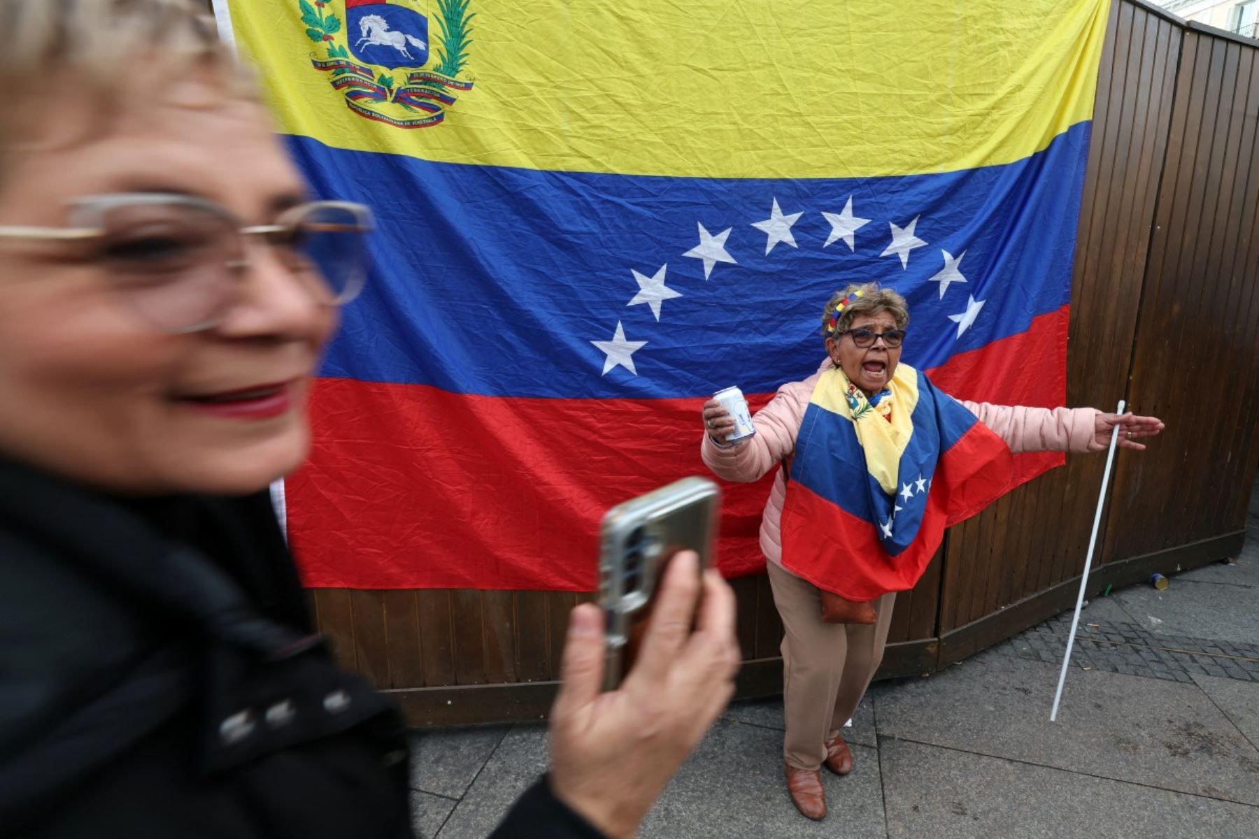 Una venezolana celebra frente a una gran bandera de su país en la Puerta del Sol, en Madrid, tras conocerse la captura de Nicolás Maduro por fuerzas estadounidenses. Con gestos espontáneos y objetos cotidianos en la mano, la escena refleja la emoción y el alivio de una diáspora que sueña con volver a casa. Foto: AFP