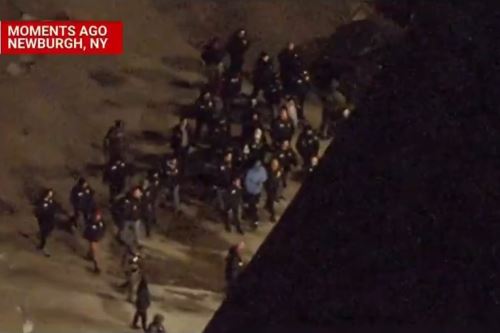 Nicolas Maduro (light blue shirt) is escorted to a military facility in the United States. Screenshot: NBC News 