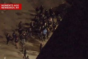 Nicolas Maduro (light blue shirt) is escorted to a military facility in the United States. Screenshot: NBC News 