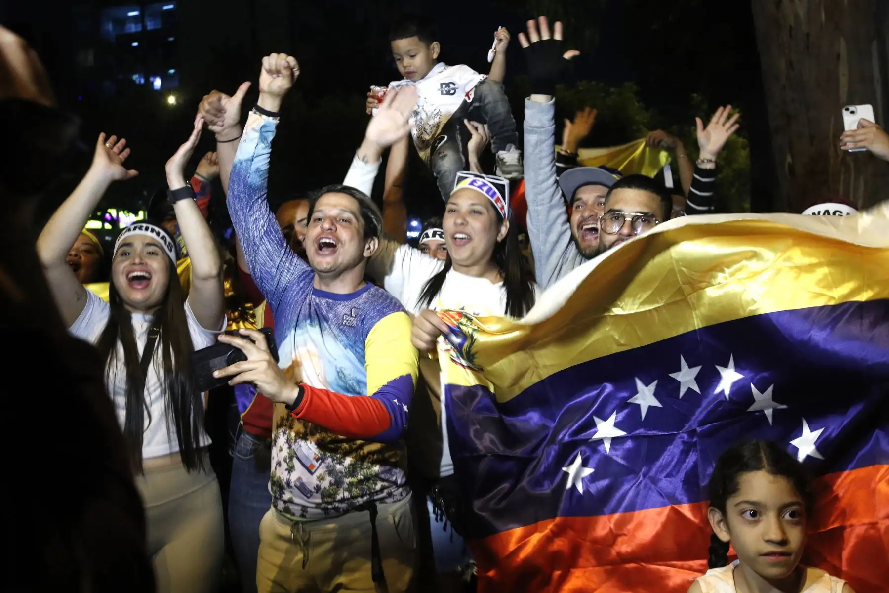 Desde la mañana, cientos de venezolanos residentes en Perú se congregaron en Lima y permanecieron celebrando hasta bien entrada la noche, incluso pasadas las 10 p. m., tras conocerse la captura de Nicolás Maduro por fuerzas estadounidenses, luego de un “ataque a gran escala” en Venezuela. Con banderas, cánticos y reuniones familiares, expresaron alivio y esperanza de un cambio político y de un eventual retorno. La prolongada vigilia reflejó el impacto regional del anuncio y la fuerza simbólica del momento. 
Foto: ANDINA/Eddy Ramos