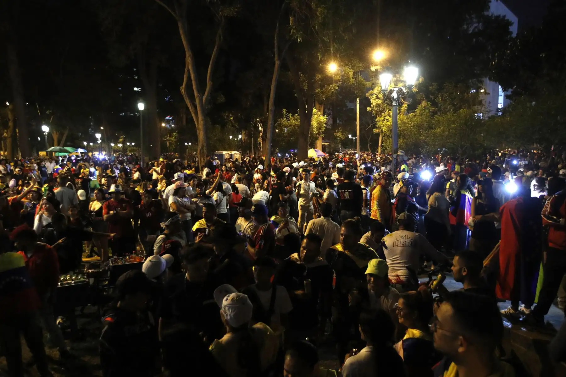 La celebración transcurrió sin incidentes y bajo un ambiente mayoritariamente festivo. A lo largo de las horas, grupos se turnaron para llegar y retirarse, mientras otros optaron por permanecer en vigilia, compartiendo alimentos, bebidas y relatos personales sobre su salida de Venezuela. 
Foto: ANDINA/Eddy Ramos