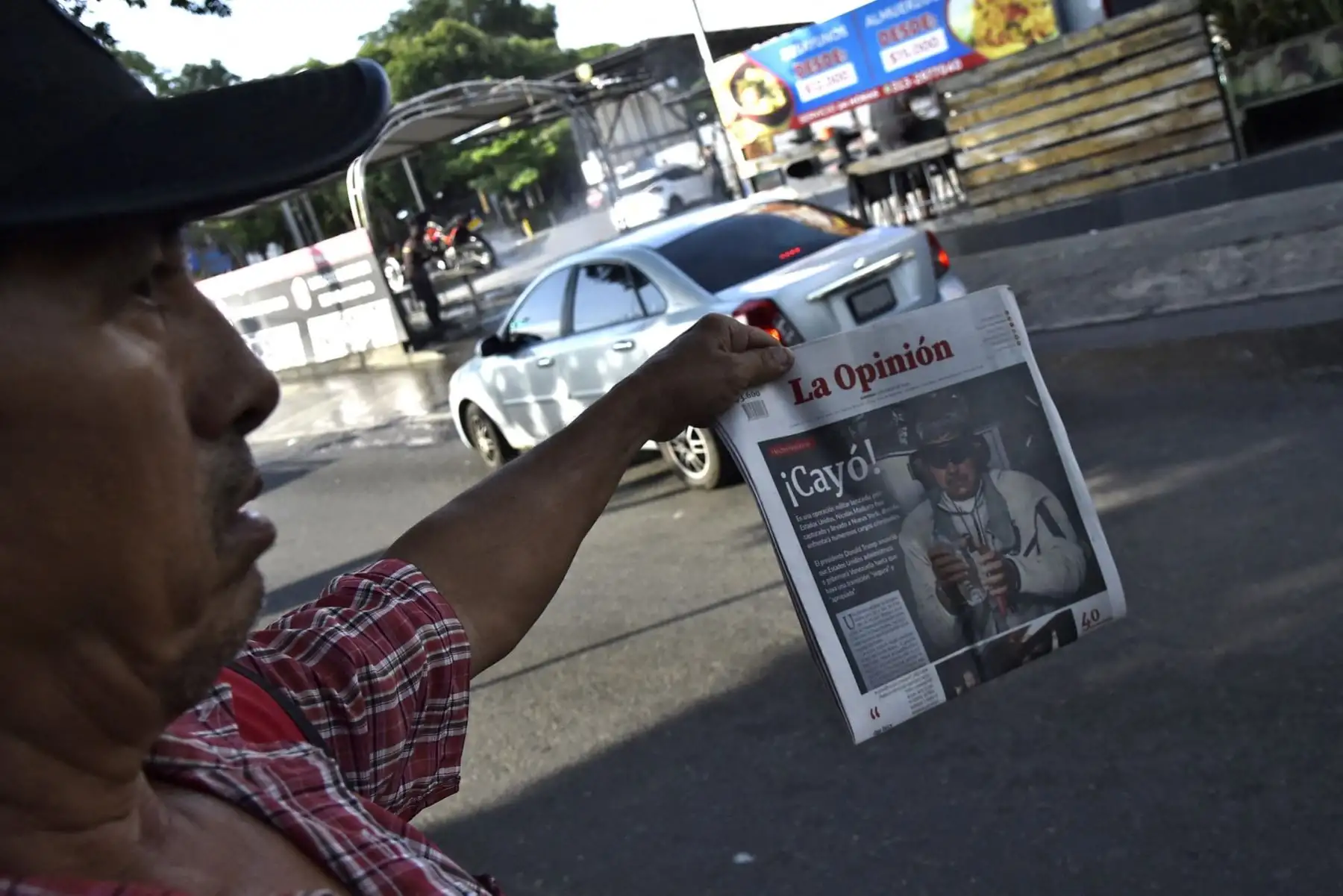 Un hombre sostiene un periódico que dice "Cayó" y representa al presidente derrocado de Venezuela, Nicolás Maduro, en la frontera entre Venezuela y Colombia, un día después de la operación militar estadounidense. Foto: AFP