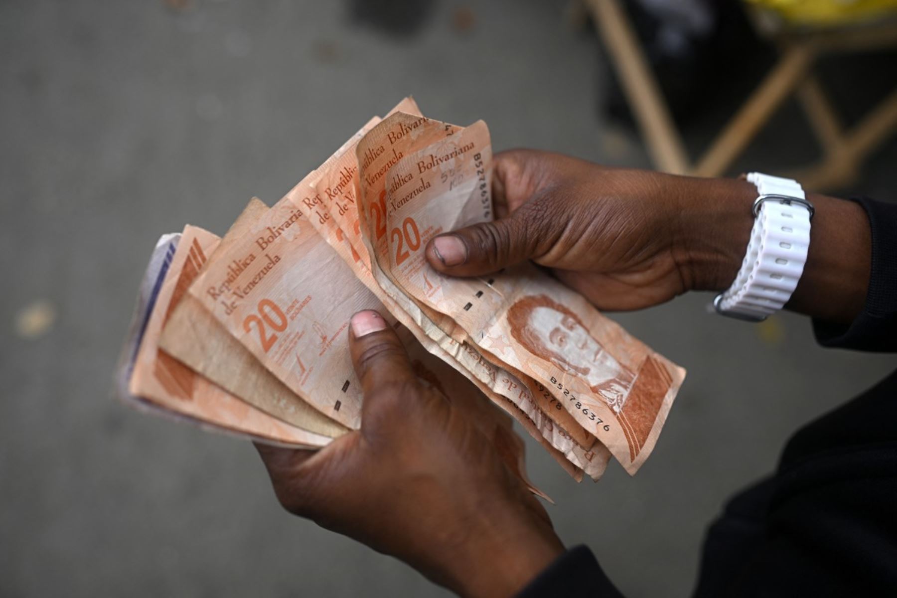 Un vendedor de café cuenta dinero en Caracas el 4 de enero de 2026, un día después de que el presidente de Venezuela, Nicolás Maduro, fuera capturado. Foto: AFP