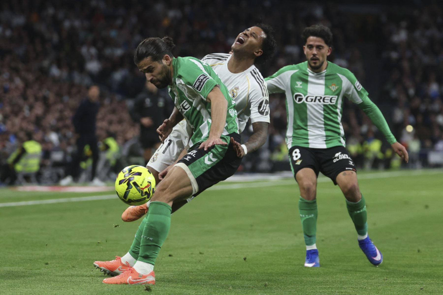 El defensor suizo del Real Betis, Ricardo Rodríguez (C), y el delantero brasileño del Real Madrid #11 Rodrygo (C) luchan por el balón durante el partido de fútbol de la Liga Española entre el Real Madrid CF y el Real Betis en el Estadio Santiago Bernabéu de Madrid el 4 de enero de 2026. (Foto de Pierre-Philippe MARCOU / AFP)