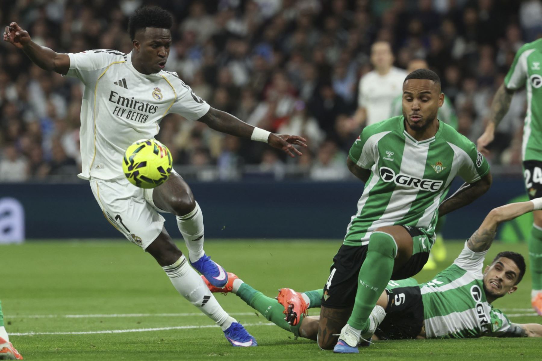 El delantero brasileño del Real Madrid #07 Vinicius Junior, el defensor brasileño del Real Betis #04 Natan Bernardo de Souza (C) y el defensor español del Real Betis #05 Marc Bartra luchan por el balón durante el partido de fútbol de la Liga española entre el Real Madrid CF y el Real Betis en el Estadio Santiago Bernabéu de Madrid el 4 de enero de 2026. (Foto de Pierre-Philippe MARCOU / AFP)