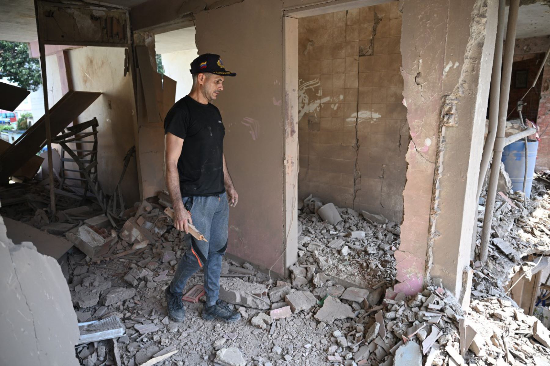 Jesús Linares camina en su apartamento dañado en Catia La Mar, estado de La Guaira, Venezuela, el 4 de enero de 2026, un día después de que el líder de Venezuela, Nicolás Maduro, fuera capturado en un ataque estadounidense.
Foto: AFP