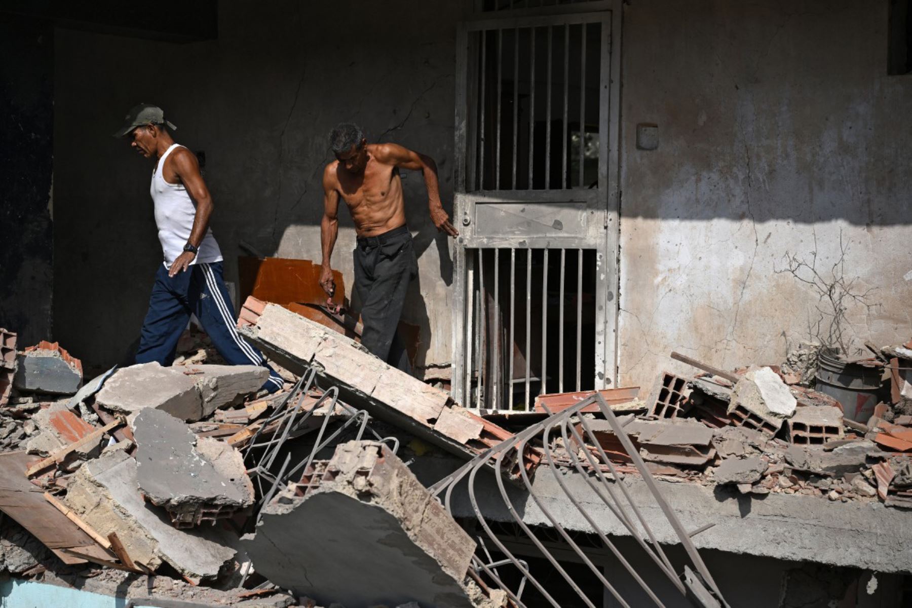 Wilman González, familiar del propietario, ayuda a limpiar un apartamento dañado en Catia La Mar, estado de La Guaira, Venezuela, el 4 de enero de 2026, un día después de que el líder de Venezuela, Nicolás Maduro, fuera capturado en un ataque estadounidense.
Foto: AFP