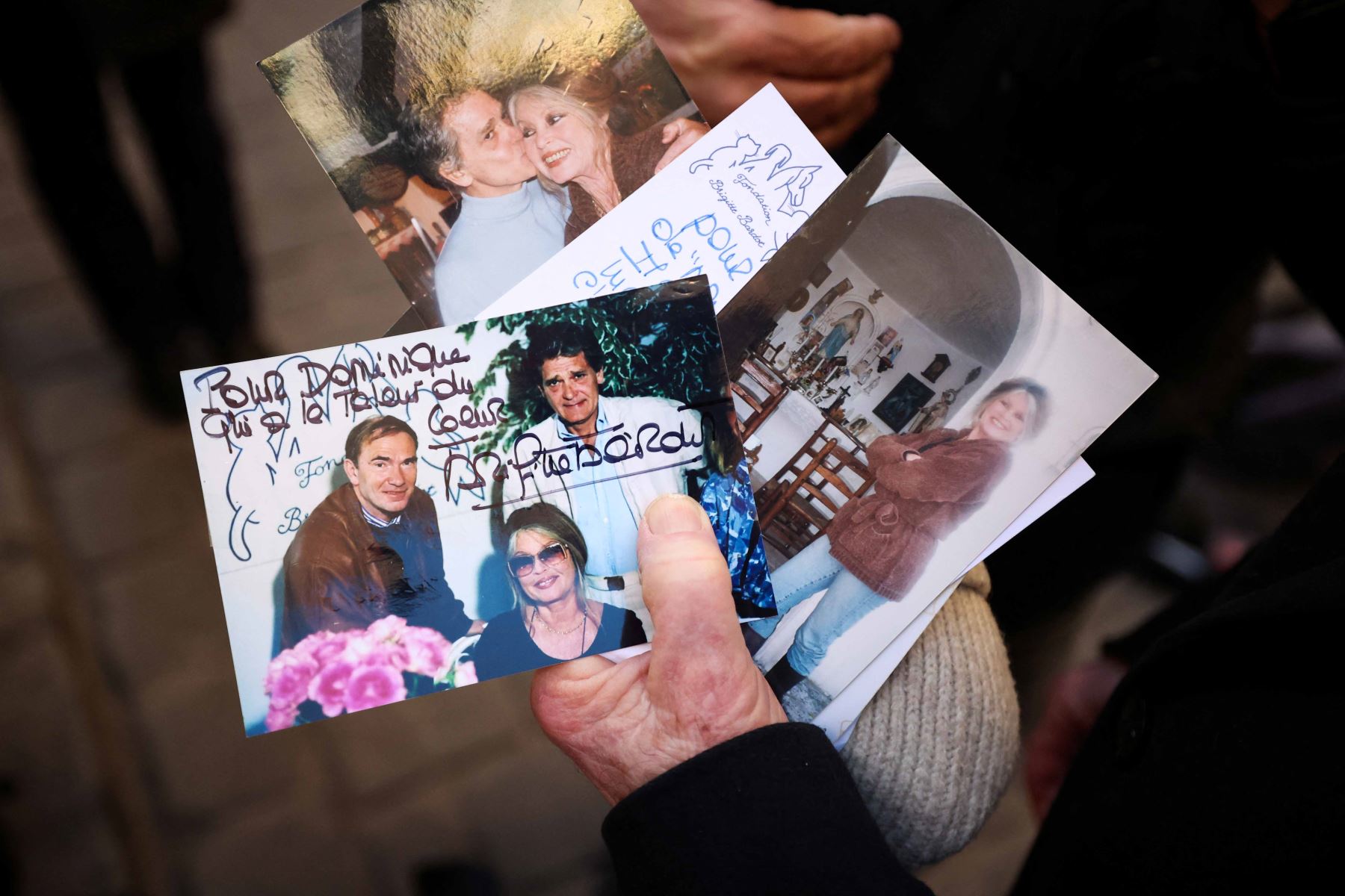 Un fan muestra fotos de la fallecida actriz francesa Brigitte Bardot mientras se reúne en las calles para rendirle homenaje antes de su funeral en la iglesia de Notre-Dame de l