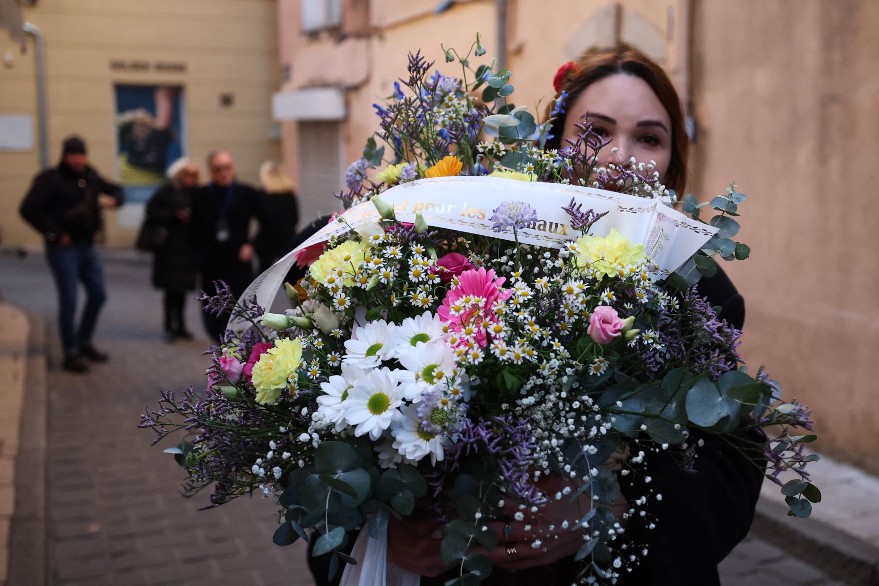 Una doliente lleva un ramo de flores mientras camina hacia la iglesia de Notre-Dame de l