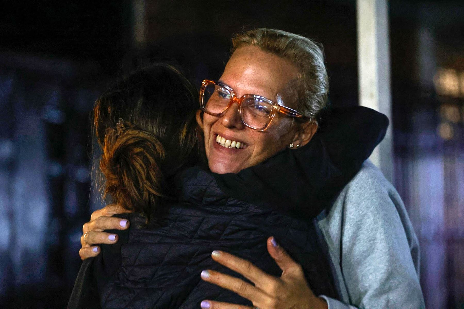 Ariana González, hija del opositor venezolano exiliado Edmundo González, abraza a una mujer mientras esperan fuera de la prisión El Rodeo en Caracas. Foto: AFP