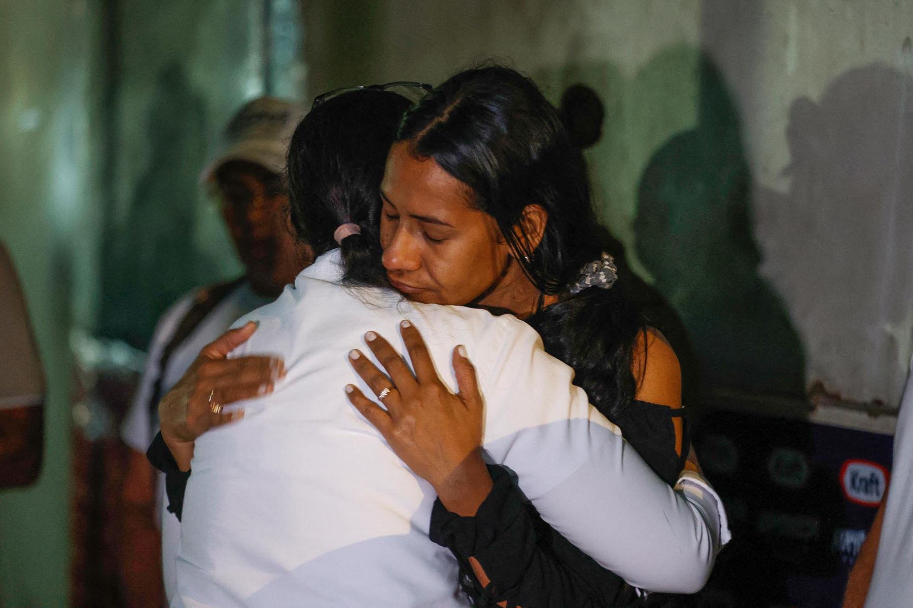 Dos mujeres reaccionan mientras participan en una oración mientras familiares de presos esperan frente a la cárcel El Rodeo en Caracas. Foto: AFP