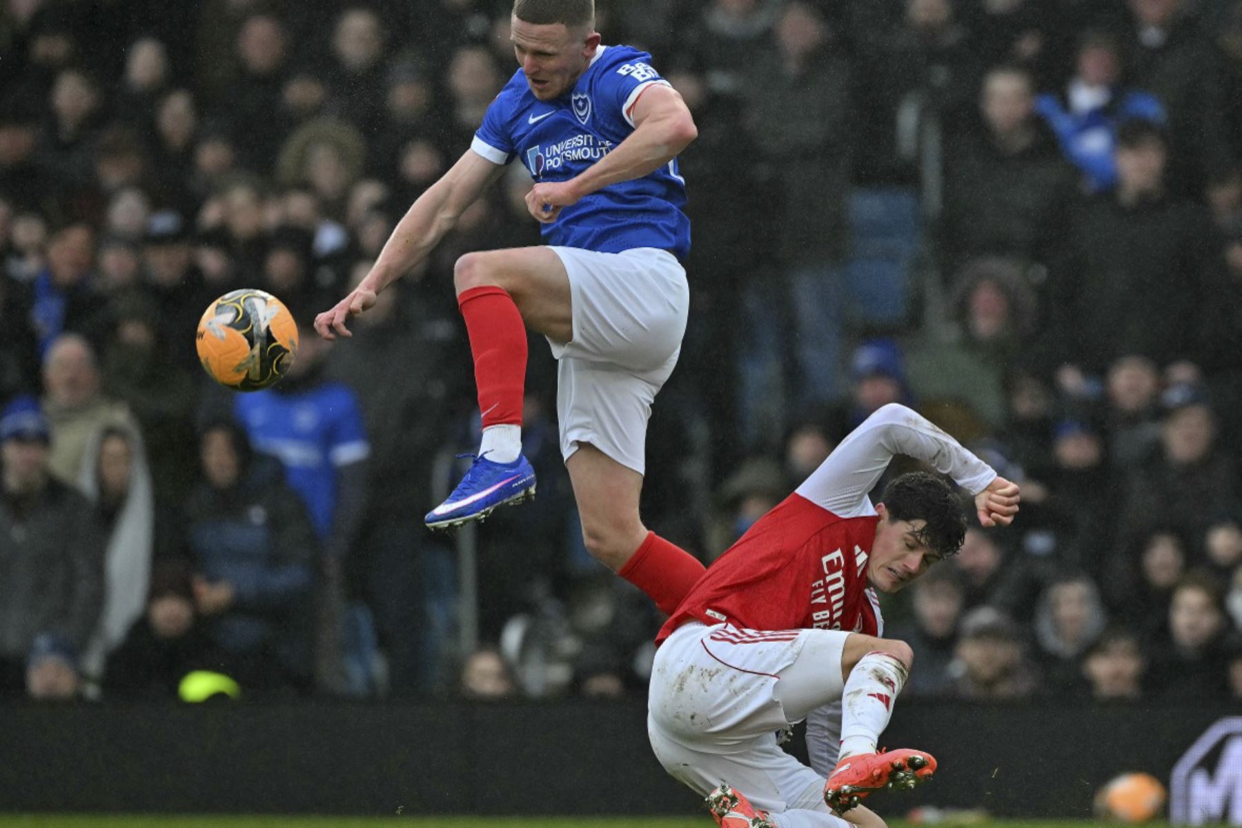 El delantero inglés del Portsmouth #09 Colby Bishop (Izquida) salta por encima del defensor danés del Arsenal #16, Christian Norgaard, para controlar el balón durante el partido de tercera ronda de la Copa FA de Inglaterra entre Portsmouth y Arsenal en Fratton Park en Portsmouth, al sur de Inglaterra, el 11 de enero de 2026. (Foto de Glyn KIRK / AFP)