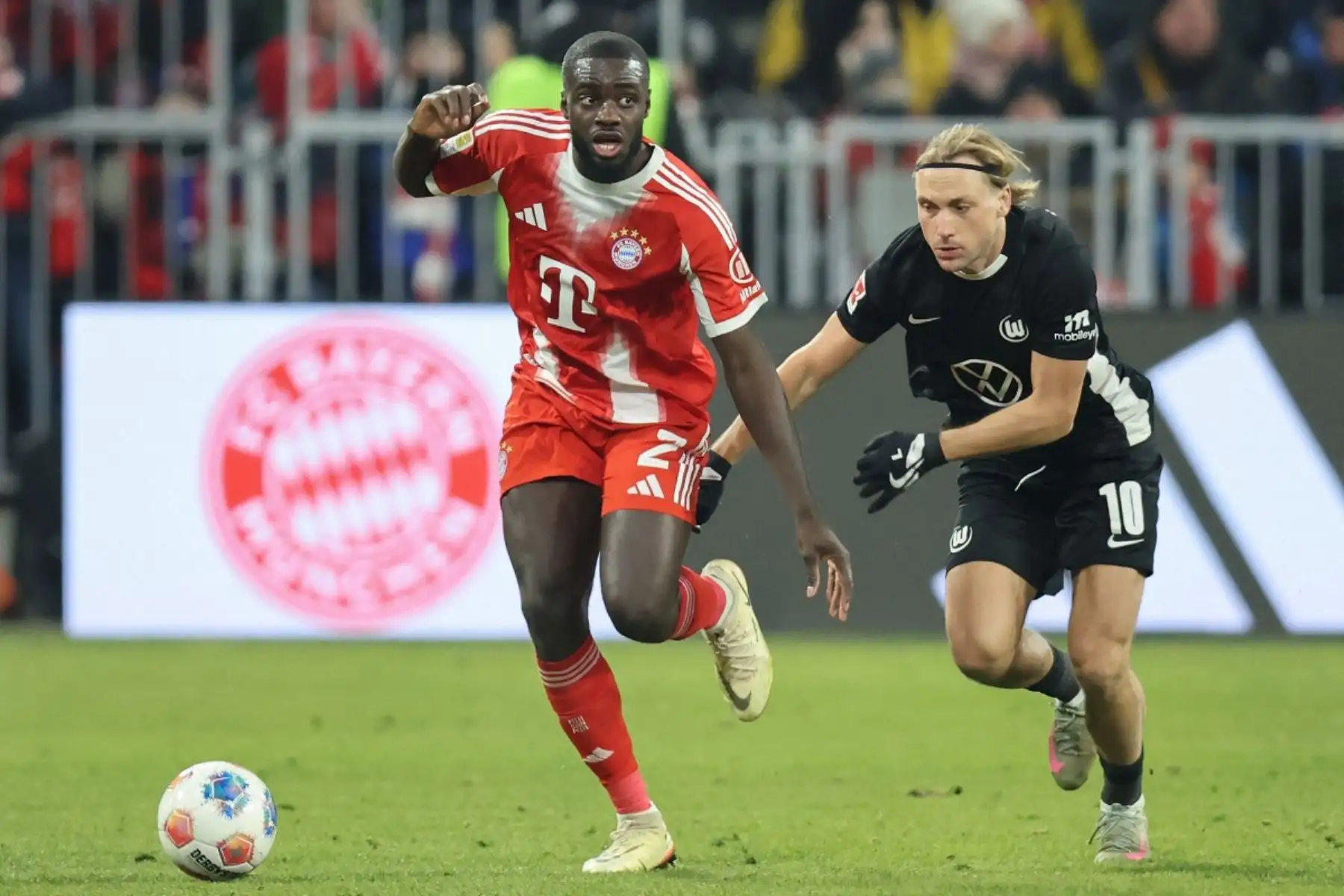 El defensor francés del Bayern de Múnich #02 Dayot Upamecano y el centrocampista croata del Wolfsburg #10 Lovro Majer compiten por el balón durante el partido de fútbol de la primera división alemana de la Bundesliga entre el FC Bayern de Múnich y el VfL Wolfsburg en Múnich, sur de Alemania, el 11 de enero de 2026. (Foto de Alexandra BEIER / AFP)
