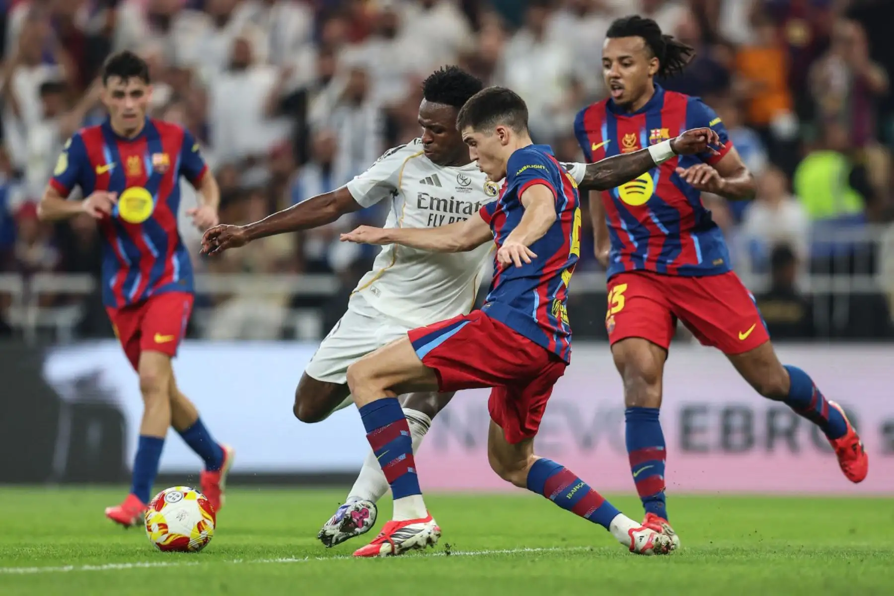El delantero brasileño del Real Madrid, Vinicius Junior , y el defensa español del Barcelona, ​​Pau Cubarsi, luchan por el balón durante la final de la Supercopa de España entre el FC Barcelona y el Real Madrid en el Estadio Rey Abdullah en Yeddah.
Foto: AFP