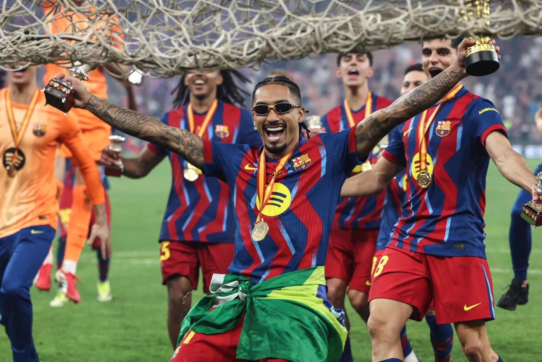 El delantero brasileño  del Barcelona, ​​​​Raphinha, celebra con sus compañeros tras ganar la final de la Supercopa de España entre el FC Barcelona y el Real Madrid en el Estadio Rey Abdullah de Yeda.
Foto: AFP